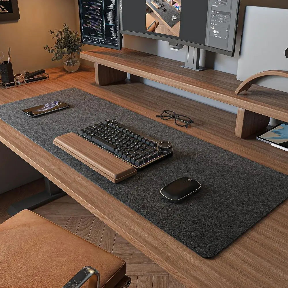 XL workspace desk pad in charcoal grey covering full wooden desk with keyboard and dual monitors